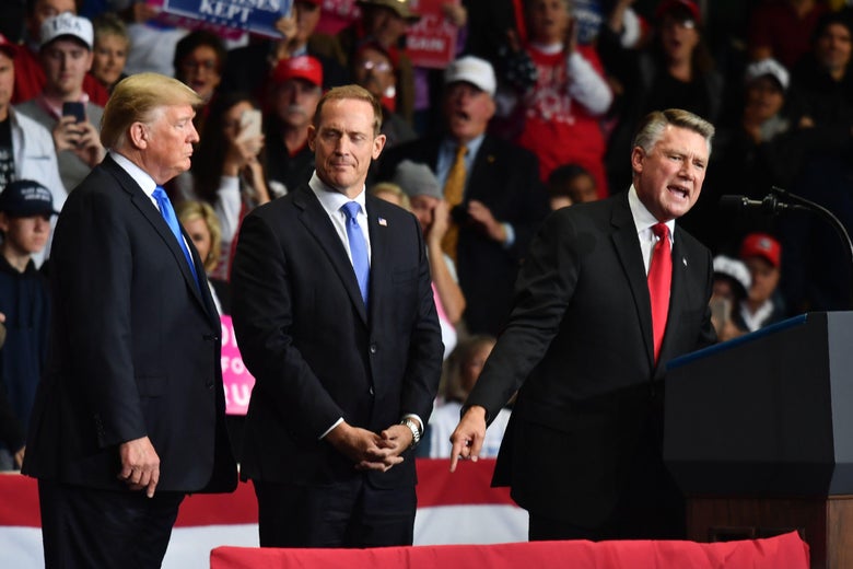 Mark Harris speaks as GOP Rep. Ted Budd and Donald Trump look on at a campaign rally in North Carolina.
